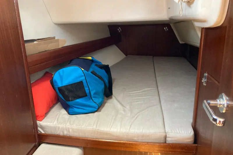 Slide: The Image of Cozy cabin interior of 2001 Bavaria 43 Cruiser with blue bag and red pillow. - 51