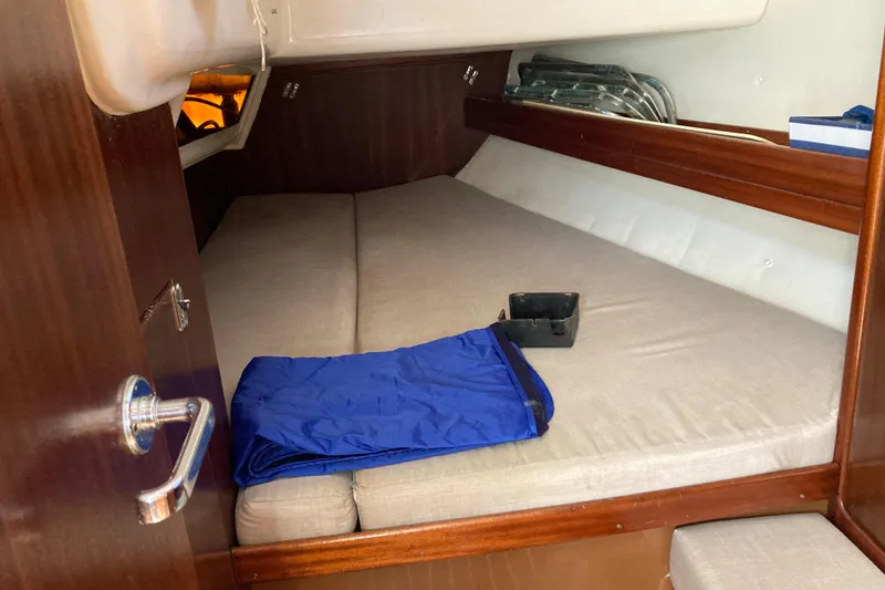 Slide: The Image of Interior cabin of 2001 Bavaria 43 Cruiser yacht with bed and blue blanket. - 52