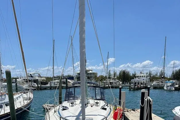 Slide: The Image of Sailboat Bavaria 42 (2001) docked in a sunny marina with clear blue skies. - 6