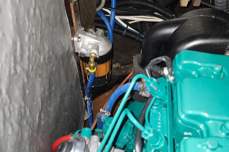 Slide: The Image of Engine compartment of a 2001 Bavaria 43 Cruiser, showcasing fuel filter and blue hoses. - 62