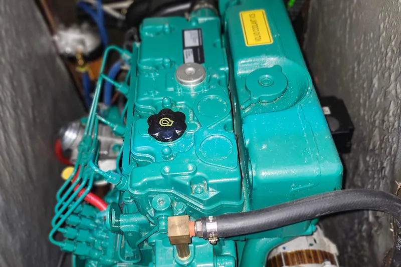 Slide: The Image of Engine of a 2001 Bavaria 43 Cruiser sailboat, featuring a teal-colored motor. - 63