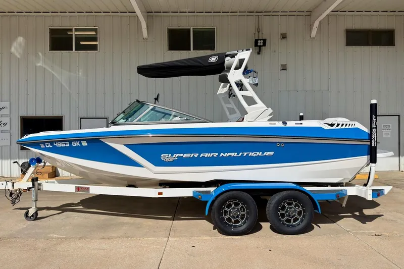 Slide: The Image of 2018 Nautique Super Air Nautique GS20 boat on trailer, blue and white design. - 0