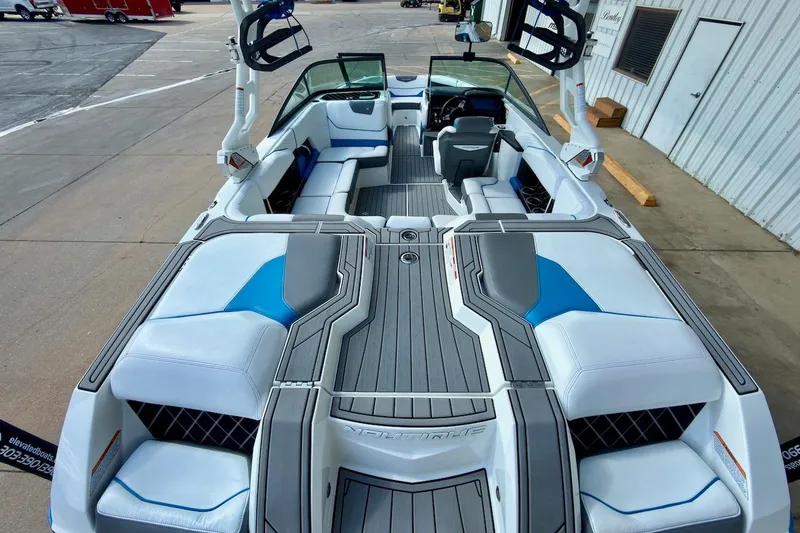 Slide: The Image of 2018 Nautique Super Air Nautique GS20 interior with white and blue seating, cup holders, and speakers. - 10