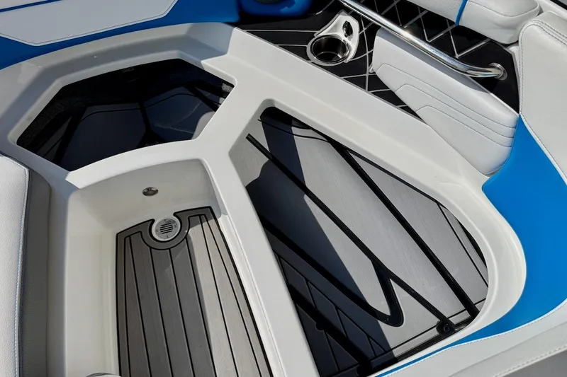 Slide: The Image of 2018 Nautique Super Air Nautique GS20 interior with cup holders and cooler storage. - 18