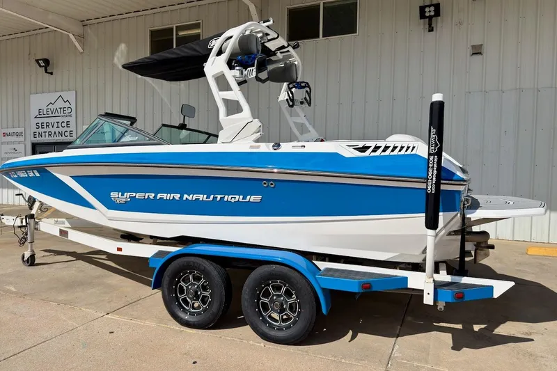 Slide: The Image of 2018 Nautique Super Air Nautique GS20 boat on trailer, blue and white design. - 4