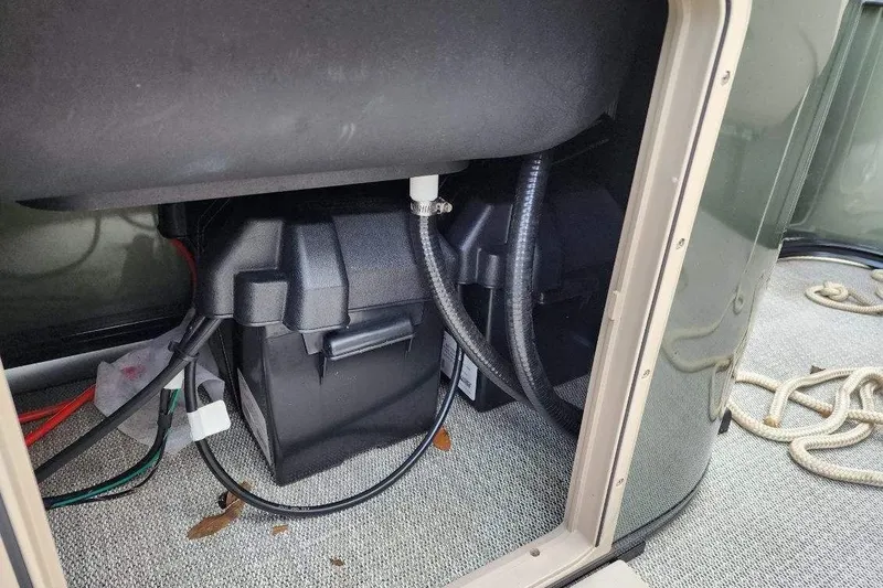 Slide: The Image of Battery compartment of 2022 Avalon GS Rear Fish 23' boat, showing cables and storage. - 11