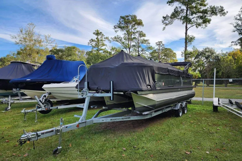 Slide: The Image of 2022 Avalon GS Rear Fish boat covered on trailer, parked on grass. - 12