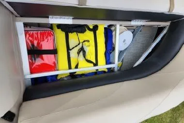 Slide: The Image of Storage compartment in 2022 Avalon GS Rear Fish boat, featuring life jackets and safety gear. - 22