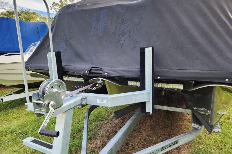 Slide: The Image of Covered Avalon GS Rear Fish 23' boat on trailer, 2022 model, parked on grass. - 26