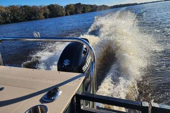 Slide: The Image of 2022 Avalon GS Rear Fish boat cruising on a lake, creating a wake. - 31