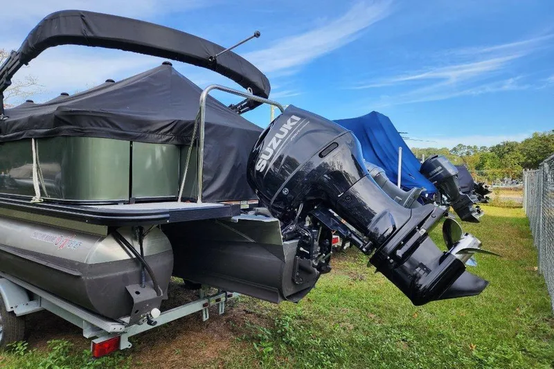 Slide: The Image of 2022 Avalon GS Rear Fish boat with Suzuki outboard motor on trailer, under blue sky. - 32
