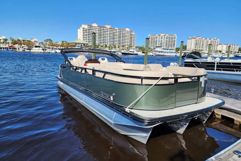 Slide: The Image of 2022 Avalon GS Rear Fish pontoon boat docked in a marina with waterfront buildings. - 34