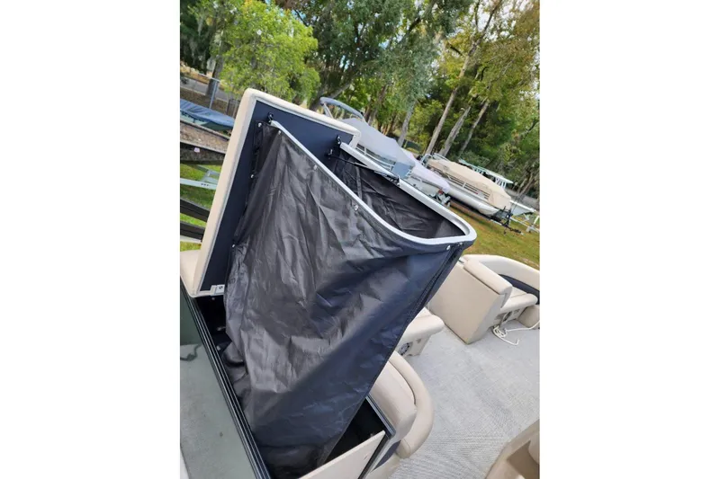 Slide: The Image of 2022 Avalon GS Rear Fish boat with open storage compartment, surrounded by trees and other boats. - 35