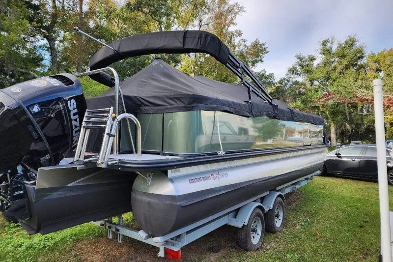 Slide: The Image of 2022 Avalon GS Rear Fish 23' pontoon boat on trailer, covered and parked outdoors. - 8