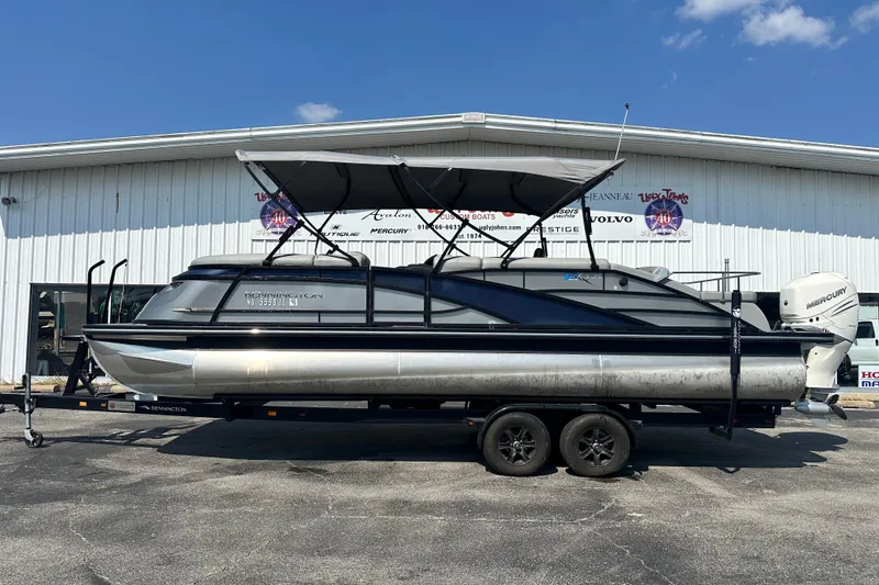 The Image of 2023 Bennington Q25 pontoon boat on trailer, parked outside a dealership. - 1