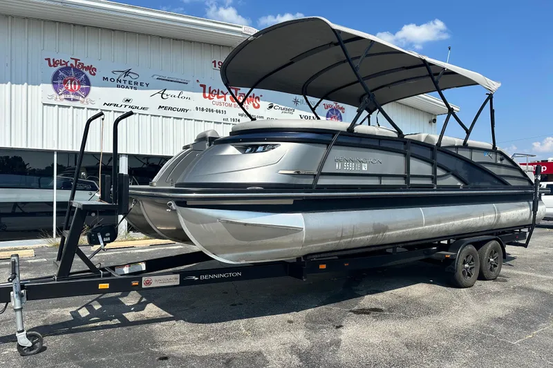 Slide: The Image of 2023 Bennington Q25 pontoon boat on trailer outside dealership. - 2