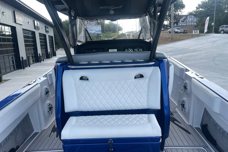 Slide: The Image of 2022 Nor-Tech 340 Sport Center Console boat interior with white seating and blue accents. - 12