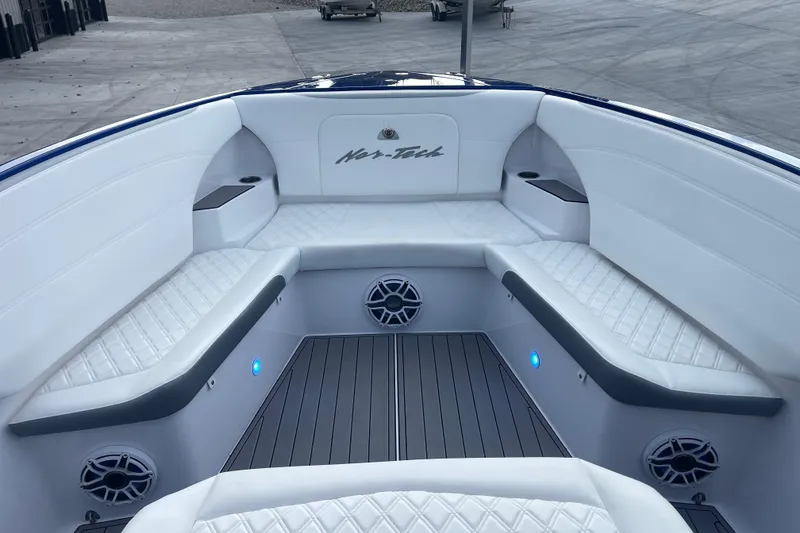 Slide: The Image of 2022 Nor-Tech 340 Sport Center Console boat interior with white seating and blue LED lights. - 23
