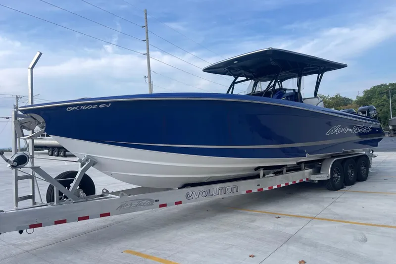 Slide: The Image of 2022 Nor-Tech 340 Sport Center Console boat on trailer, blue and white design. - 8