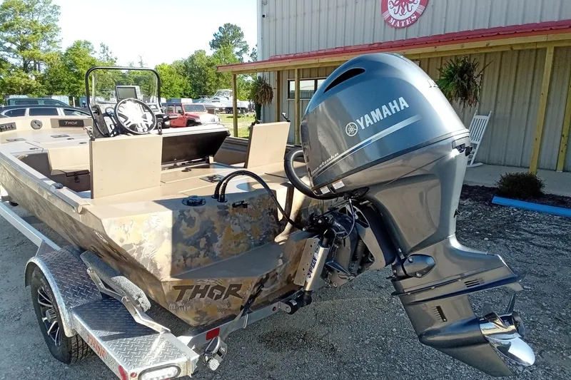 Slide: The Image of 2025 Thor 1900 Lake Hammer boat with Yamaha outboard motor, parked outdoors. - 10