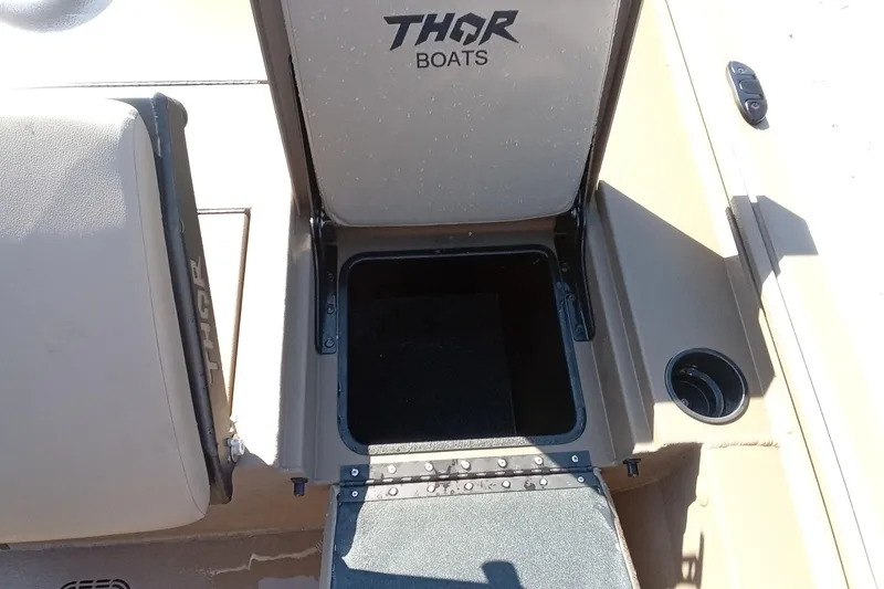 Slide: The Image of Thor 1900 Lake Hammer 2025 boat storage compartment with open lid and cup holder. - 18