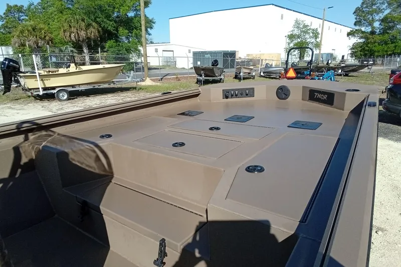 Slide: The Image of 2025 Thor 1900 Lake Hammer boat, brown deck, outdoor setting, parked near other boats. - 7