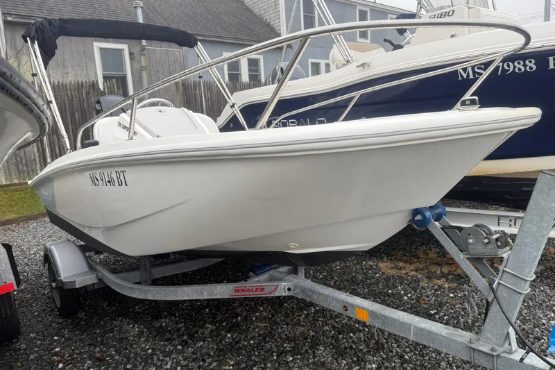 The Image of 2020 Boston Whaler 130 Super Sport boat on trailer, parked outdoors. - 0