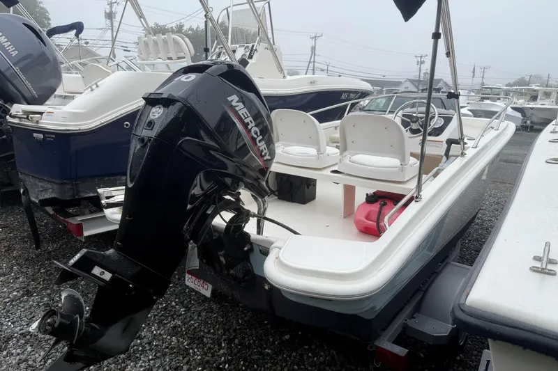 Slide: The Image of 2020 Boston Whaler 130 Super Sport boat with Mercury outboard motor in a marina. - 3