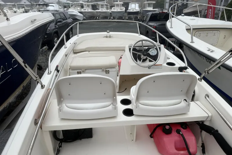 Slide: The Image of 2020 Boston Whaler 130 Super Sport boat interior with steering wheel and seating. - 4