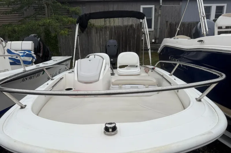 Slide: The Image of 2020 Boston Whaler 130 Super Sport boat with seating and railing, docked outdoors. - 5