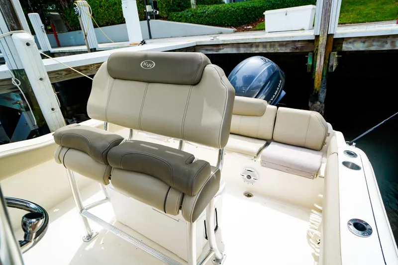 Slide: The Image of 2022 Key West 219 FS boat interior with cushioned seating and Yamaha outboard motor. - 10