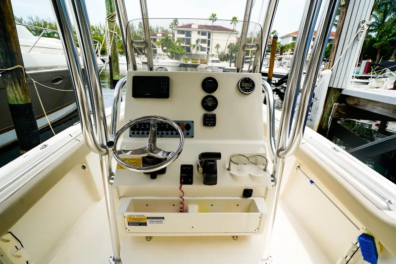 Slide: The Image of 2022 Key West 219 FS boat console with steering wheel and gauges at marina. - 13