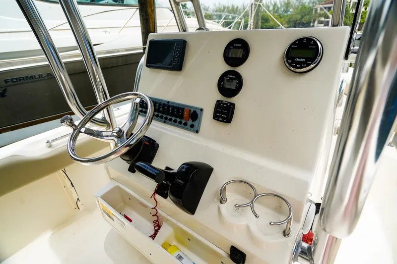 Slide: The Image of 2022 Key West 219 FS boat dashboard with steering wheel and control panel. - 15