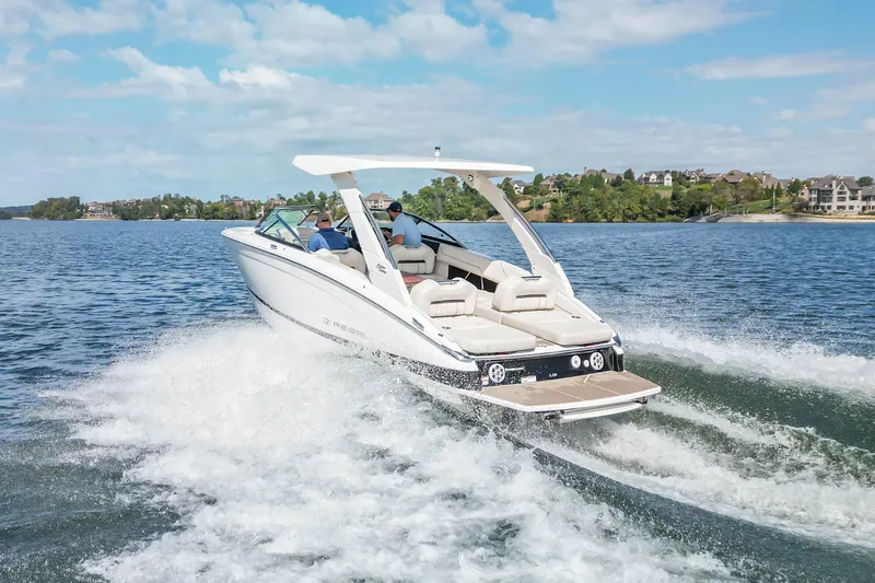 Slide: The Image of 2022 Regal LS6 boat cruising on a scenic lake with passengers onboard. - 15