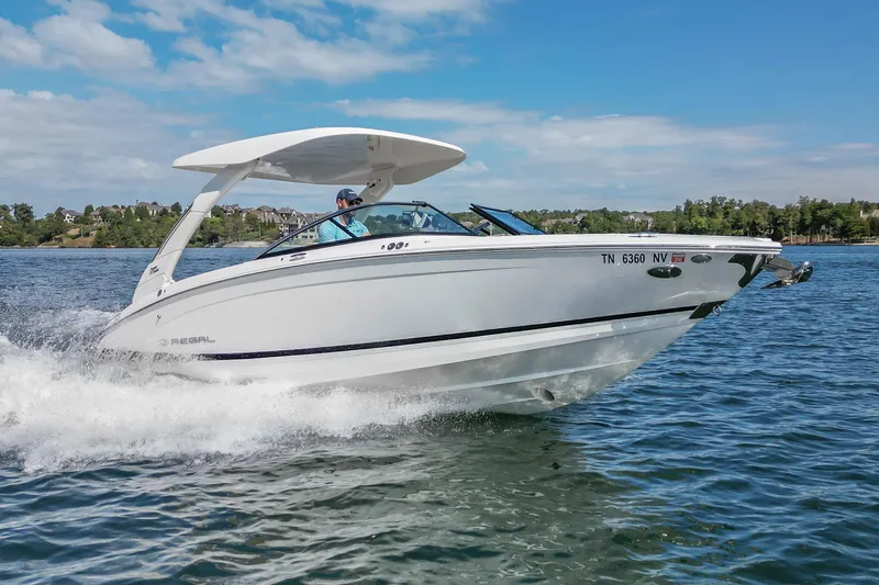 Slide: The Image of 2022 Regal LS6 boat cruising on a lake under a clear blue sky. - 17