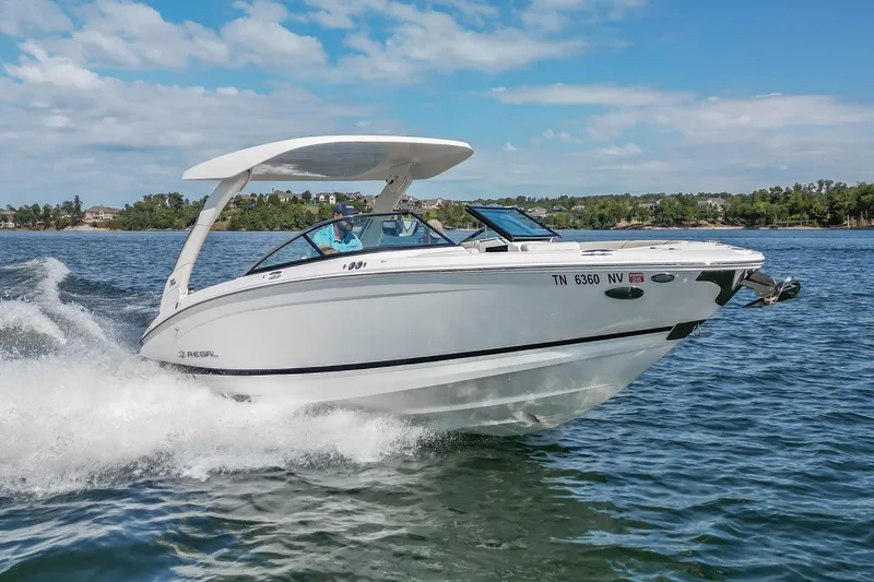 Slide: The Image of 2022 Regal LS6 boat cruising on a lake with a scenic background. - 19