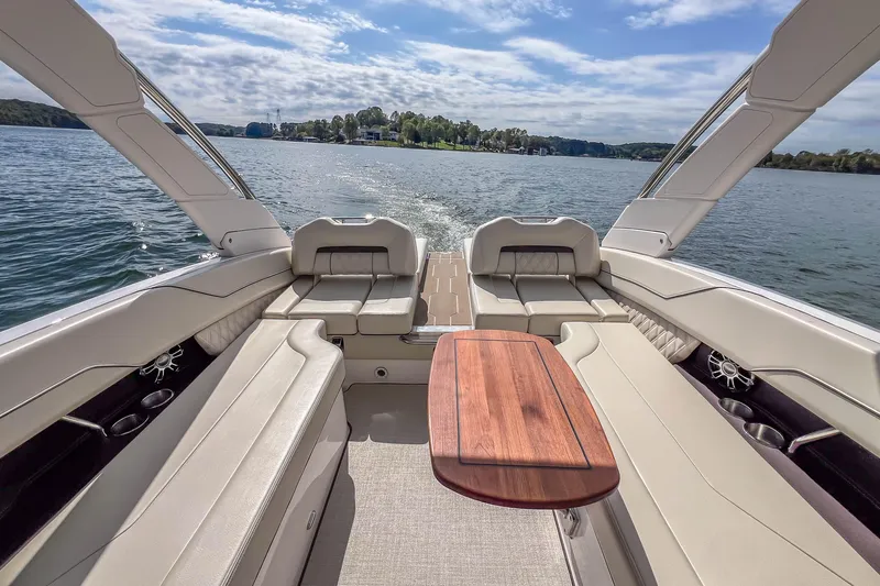 Slide: The Image of Luxurious 2022 Regal LS6 boat interior with elegant seating and wooden table on a serene lake. - 21