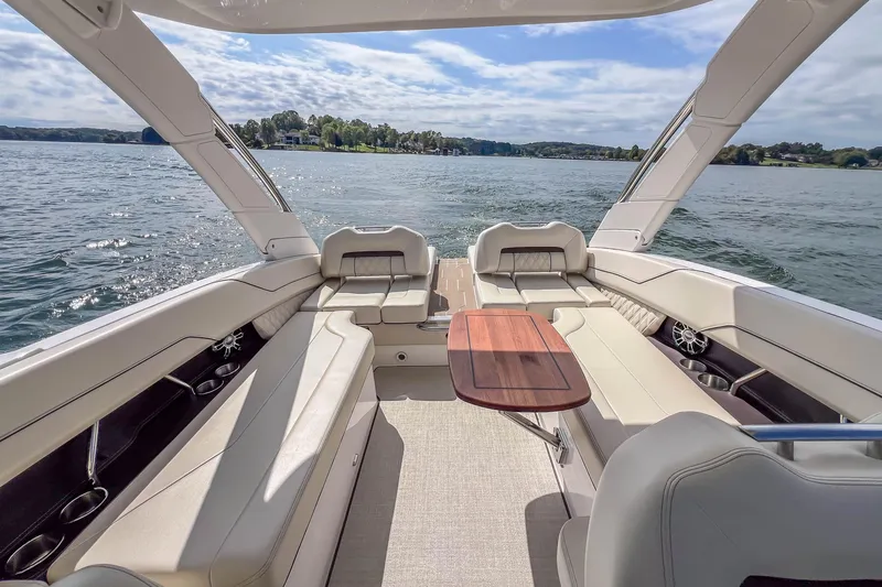 Slide: The Image of Luxurious 2022 Regal LS6 boat interior with elegant seating and wooden table on a sunny day. - 22