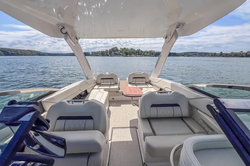 Slide: The Image of 2022 Regal LS6 boat interior with luxurious seating on a serene lake. - 23