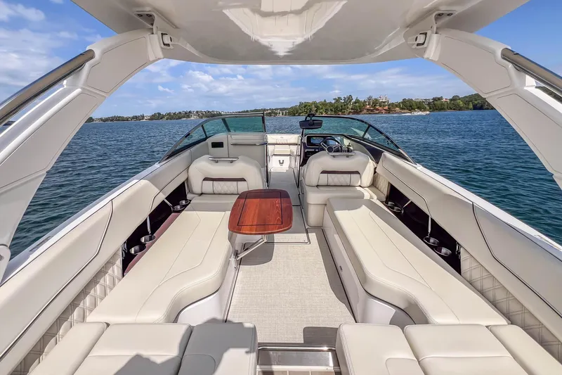 Slide: The Image of Luxurious 2022 Regal LS6 boat interior with white seating and wooden table on a sunny day. - 27