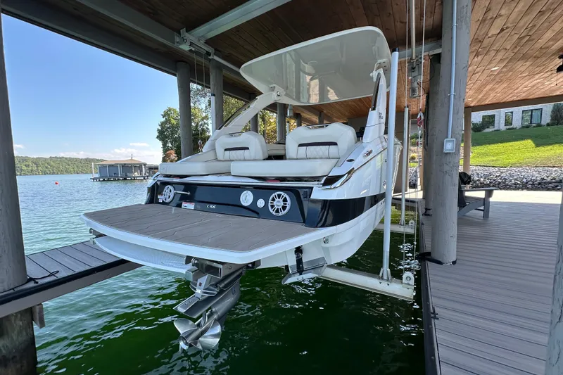 Slide: The Image of 2022 Regal LS6 boat cruising on a scenic lake under a clear blue sky. - 3