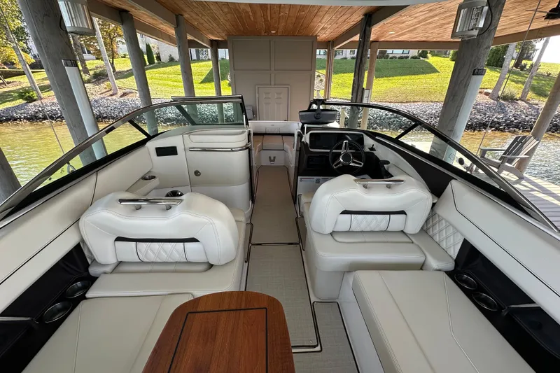 Slide: The Image of 2022 Regal LS6 boat cruising on a scenic lake with lush green shoreline. - 6