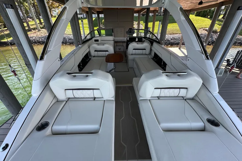 Slide: The Image of 2022 Regal LS6 boat cruising on a scenic lake with passengers onboard. - 9