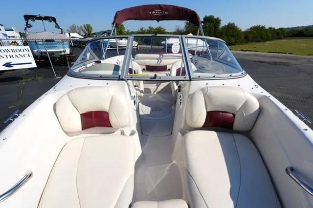 Slide: The Image of 2011 Tahoe Q5SI boat with white and maroon seating, parked outdoors. - 9