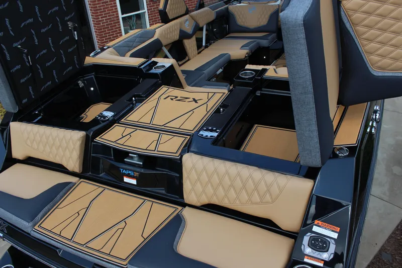 Slide: The Image of 2026 Tigé 24RZX boat interior with tan and black upholstery, featuring RZX branding. - 16
