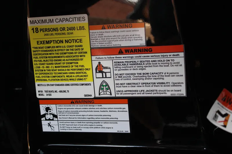 Slide: The Image of Warning labels on 2026 Tigé 24RZX boat, detailing capacity and safety instructions. - 21