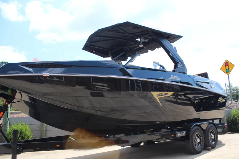Slide: The Image of 2026 Tigé 24RZX boat on trailer, sleek black design, sunny day background. - 7