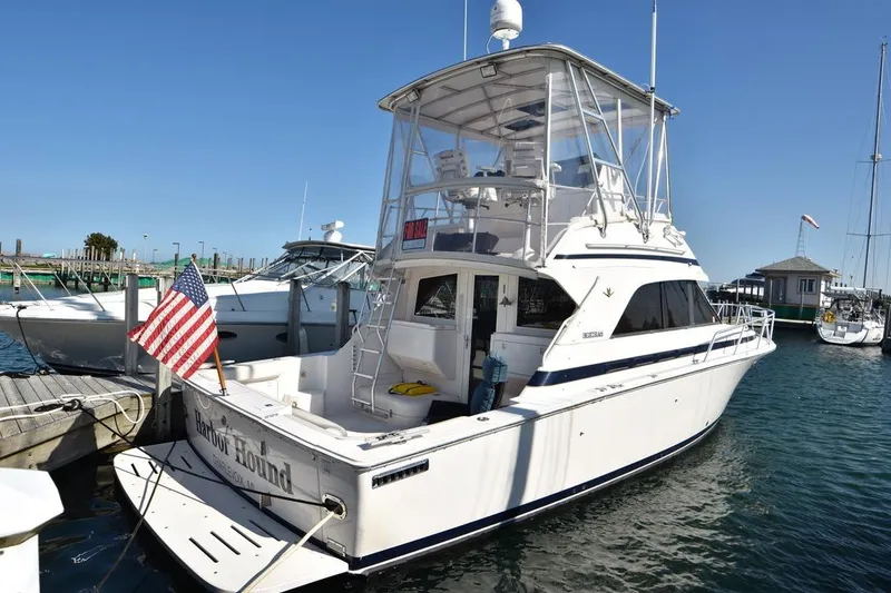 The Image of 1996 Bertram 36' Convertible yacht docked with American flag displayed. - 1