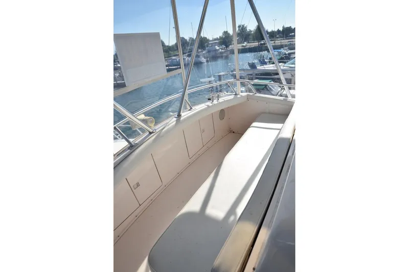 Slide: The Image of 1996 Bertram 36' Convertible boat interior with seating, overlooking marina. - 6