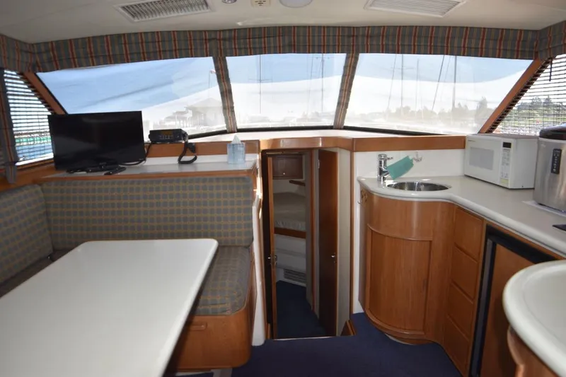 Slide: The Image of Interior of a 1996 Bertram 36' Convertible yacht with kitchenette and seating area. - 7